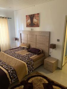 a bedroom with a bed and a picture on the wall at Villa trois chambres avec piscine in Cotonou