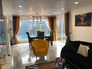 a living room with a table and a yellow chair at Villa trois chambres avec piscine in Cotonou