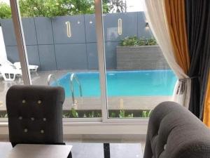 uma vista para uma piscina através de uma janela em Villa trois chambres avec piscine em Cotonou