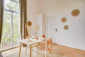 een eetkamer met een tafel en stoelen en een raam bij Appartement rénové, situation idéale à Libourne in Libourne