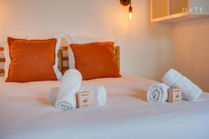 een wit bed met handdoeken en dozen erop bij Appartement rénové, situation idéale à Libourne in Libourne
