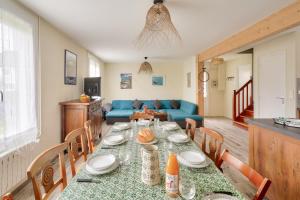 a dining room and living room with a table and chairs at À 200m de la plage de Langoz - Maison pour 10 in Loctudy +15 photos