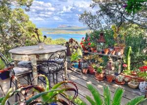 a table with chairs and potted plants on a deck at Villa Khepri in Porto Rotondo