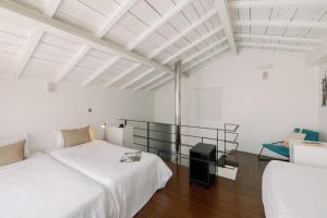 a white room with two beds and a chair at Fine Arts Studios by Olala Homes in Porto