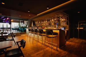 un bar con una fila de taburetes en un restaurante en Oro Inn Hotel en Shkodër