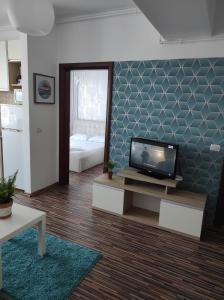 sala de estar con TV de pantalla plana en la pared en SeaView Cancun Apartments Summerland Mamaia, en Mamaia