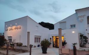 un edificio blanco con un cartel. en Hôtel le Calypso, en Hyères