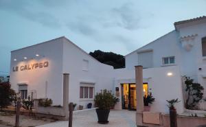 a white building with a sign on it at Hôtel le Calypso in Hyères