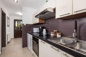 a kitchen with white cabinets and a sink at MLADENKA apartment in Kraljevica