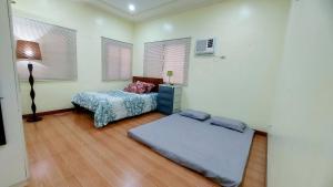 a bedroom with a bed and a table in it at Liturs house in Bacolod