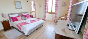1 dormitorio con 1 cama con almohadas rosas en La Vernassonne, en Alzonne