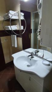 a bathroom with a white sink and a mirror at Pensiunea Select in Arad