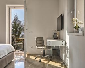 una camera con scrivania, sedia e letto di SalvatoreHomes - Luxury Villa with private Garden & BBQ a San Zeno di Montagna