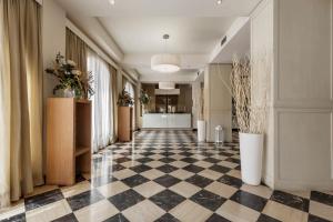 a hallway with a black and white checkered floor at Hotel Catalunya in Alghero