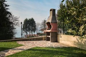 a brick fireplace sitting on top of a lawn at SalvatoreHomes - Luxury Villa with private Dream Garden & BBQ - Casa Palma - a 5 Star Luxury Collection at Lake Garda in San Zeno di Montagna