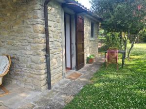 una casa de piedra con mesa y sillas al aire libre en Agriturismo PEDROSOLA, en Brisighella