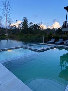 - une piscine d'eau bleue dans la cour dans l'établissement Monarch Campestre, à Rionegro