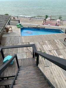 a swimming pool on a wooden deck next to the ocean at Casa heysol in Bahía de Caráquez