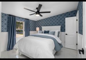 a bedroom with a bed and a ceiling fan at Chic Naples cottage 7 min from the beach in Naples