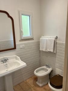 a bathroom with a sink and a toilet and a mirror at Maison d'Orange - La Pinede in Saint-Tropez