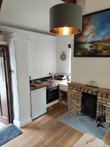 穆林加爾的住宿－Catstone Lodge Studio 2，带壁炉的厨房以及墙上的绘画作品
