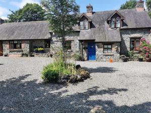 an old stone house with a blue door at Catstone Lodge Studio 2 in Mullingar