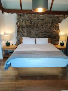 um quarto com uma cama grande e uma parede de pedra em Catstone Lodge Studio 2 em Mullingar