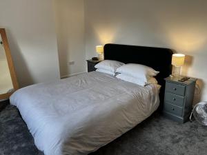 um quarto com uma cama grande, 2 mesas de cabeceira e 2 candeeiros. em Luxury apartment with 2-Beds em Beckenham
