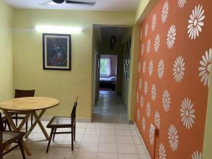a dining room with a table and chairs and a wall with flowers at Ps Homes in central Kolkata in Kolkata