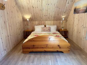 1 dormitorio con 1 cama en una habitación de madera en Latkrantė, en Latežeris