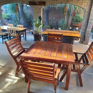 mesa de madera y sillas con mesa y bancos en Rooms @Kosmos, en Mokopane