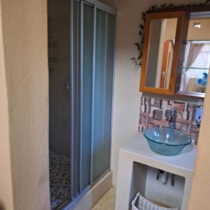 Un baño con ducha de cristal y lavabo. en Rooms @Kosmos, en Mokopane