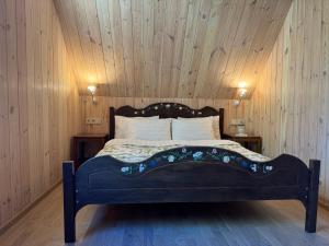 Cama en habitación con pared de madera en Latkrantė, en Latežeris