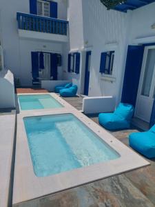 a large swimming pool with blue pillows in a room at Mata's Apartments in Tinos