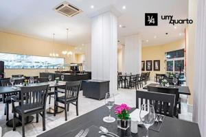un restaurant avec des tables et des chaises noires et une salle à manger dans l'établissement MANHATTAN FLOOR, à Curitiba