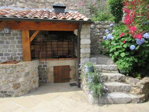 ein Steingebäude mit einer Holztür und Blumen in der Unterkunft La Grange in Vals-les-Bains