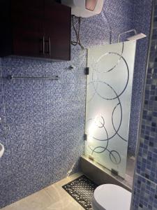een badkamer met een glazen douche en een toilet bij The Vinesplash in Chantan
