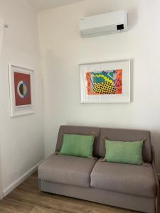 a couch in a living room with a white wall at Maison d'Orange - La Pinede in Saint-Tropez