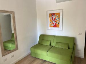a green couch in a room with a mirror at Maison d'Orange - La Pinede in Saint-Tropez