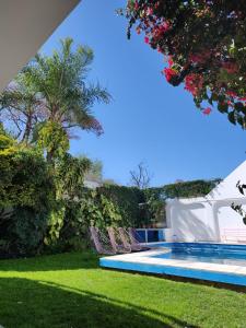 une cour avec des chaises et une piscine dans l'établissement "La Almagro", à San Fernando del Valle de Catamarca
