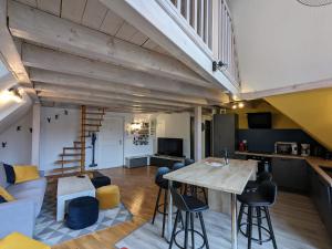 a kitchen and living room with a table and chairs at Appartement Le Ch'ti Alsacien in Eguisheim