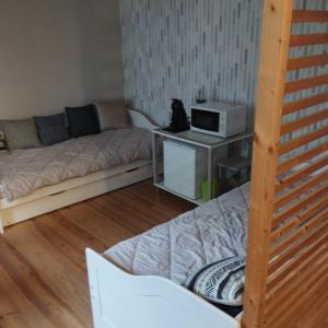 a living room with a couch and a microwave at Au fil des champs in Berzée