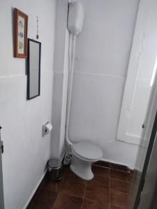 a small bathroom with a toilet and a mirror at Casa Centenária localizada no coração da cidade in São Luiz do Paraitinga