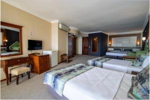 クシャダスにあるSCALA NUOVA BEACH HOTELのベッド2台とデスクが備わるホテルルームです。