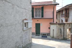 an alley with a building with a green door at B&B Località Manzoniane in Lecco