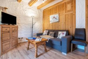 a living room with a couch and a tv and a table at Stofnerhof Turmgemach in Sarntal