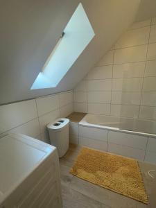 uma casa de banho com uma banheira e uma clarabóia em BullsLiving Seeapartment 4 AM CORSO em Velden am Wörthersee