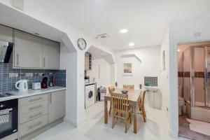 a kitchen and dining room with a table and chairs at Indipendent flat with patio in Greenford