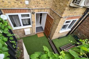 an overhead view of a backyard with a door and grass at Indipendent flat with patio in Greenford