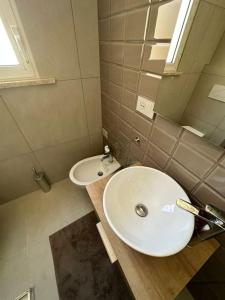 ein Badezimmer mit einem weißen Waschbecken und einem Spiegel in der Unterkunft Appartamento a pochi passi dal mare in Bellaria-Igea Marina + 21 Fotos